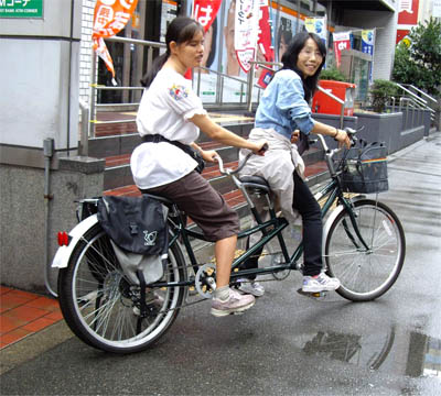タンデム自転車に乗る女性２人